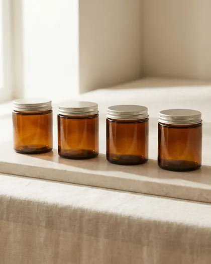 Four amber glass jars with silver lids